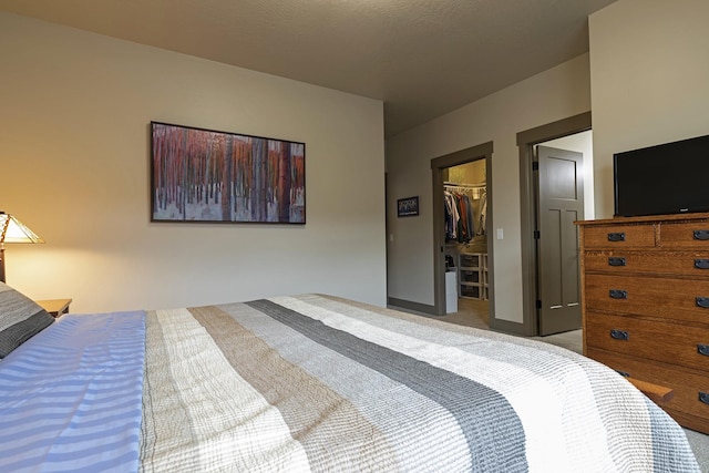 bedroom with carpet floors, a spacious closet, and a closet