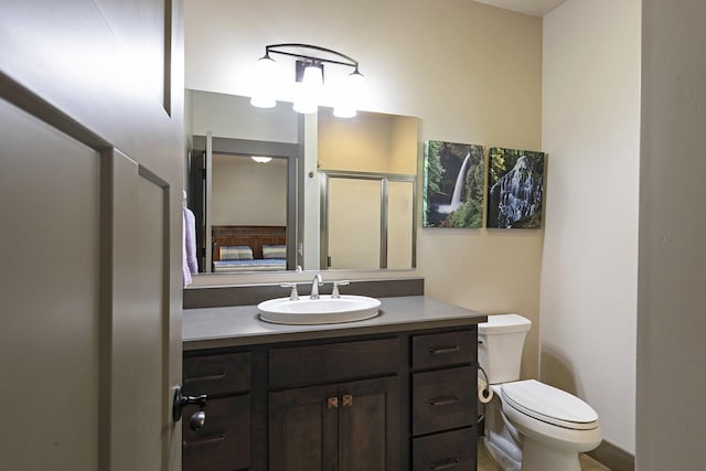 bathroom featuring toilet, a stall shower, and vanity