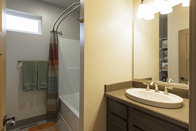 bathroom with shower / tub combo, vanity, and visible vents