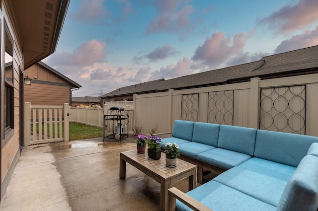 patio terrace at dusk with a fenced backyard and an outdoor hangout area