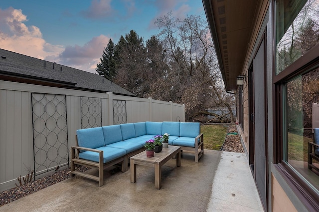 patio terrace at dusk featuring fence and an outdoor hangout area