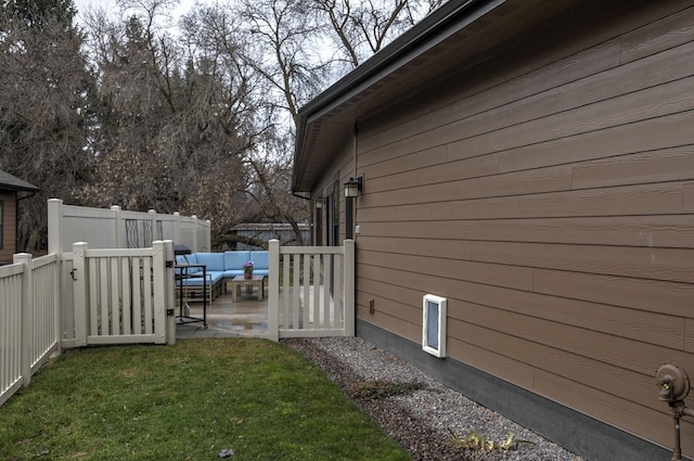 view of property exterior featuring an outdoor hangout area, a yard, a patio area, and fence