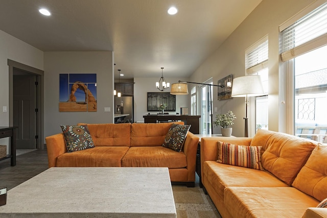 living area featuring a notable chandelier, dark wood-type flooring, and recessed lighting