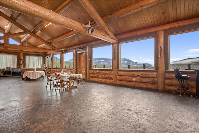 sunroom with vaulted ceiling with beams, wood ceiling, and a mountain view