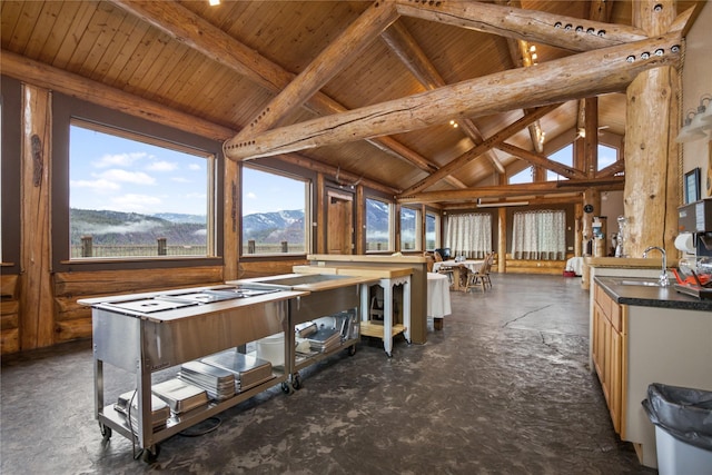 miscellaneous room with a wealth of natural light, beam ceiling, a sink, and a mountain view