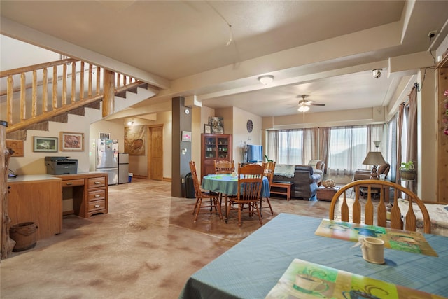 dining area with finished concrete floors, stairs, and a ceiling fan