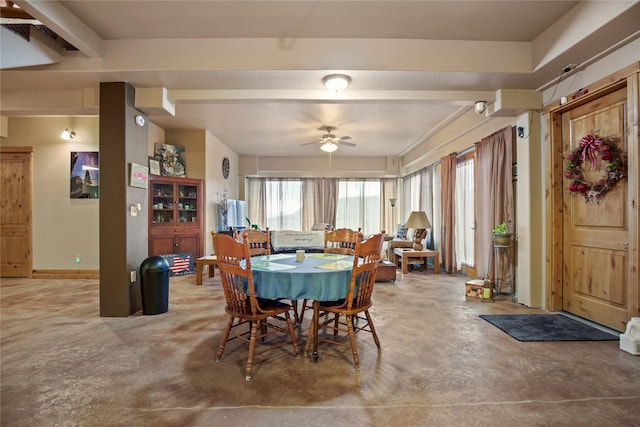 dining space featuring concrete flooring, ceiling fan, and baseboards