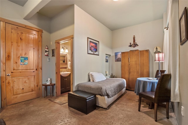 bedroom featuring light carpet, ensuite bath, and a sink