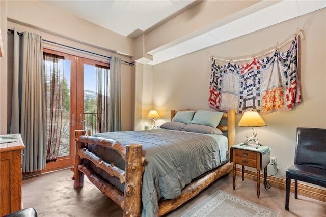 bedroom featuring french doors, finished concrete flooring, and baseboards