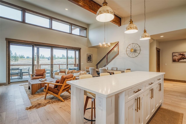 30 Ninebark Way, Eureka, MT 59917 - kitchen with a breakfast bar area, light wood finished floors, beamed ceiling, white cabinets, and a high ceiling
