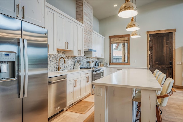 30 Ninebark Way, Eureka, MT 59917 - kitchen featuring appliances with stainless steel finishes, light countertops, decorative backsplash, a center island, and light wood-style floors