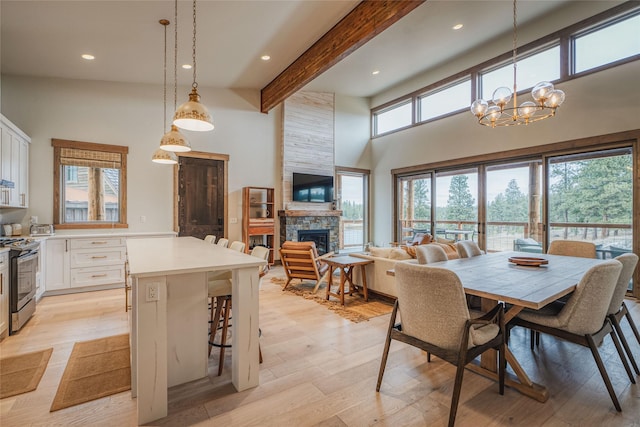 30 Ninebark Way, Eureka, MT 59917 - dining space featuring a fireplace, beamed ceiling, a notable chandelier, and light wood-style floors