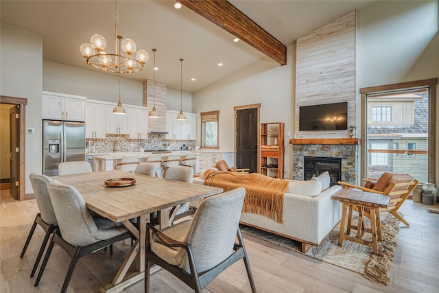30 Ninebark Way, Eureka, MT 59917 - dining room featuring an inviting chandelier, high vaulted ceiling, beam ceiling, a fireplace, and a wealth of natural light