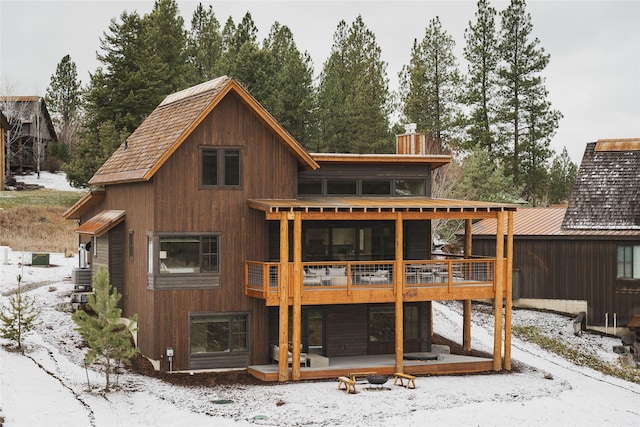 30 Ninebark Way, Eureka, MT 59917 - snow covered back of property featuring a deck and a chimney