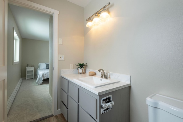 bathroom with toilet, baseboards, a baseboard heating unit, and vanity