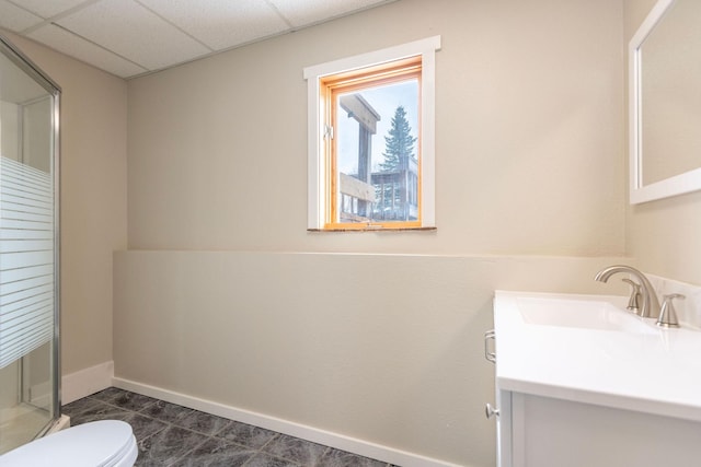 full bathroom with toilet, vanity, tile patterned flooring, a drop ceiling, and baseboards