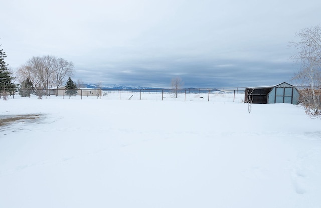 snowy yard with an outbuilding, an outdoor structure, and fence