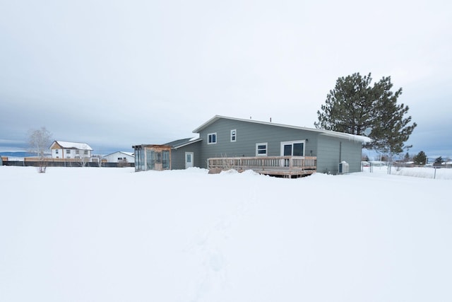 snow covered property with a deck