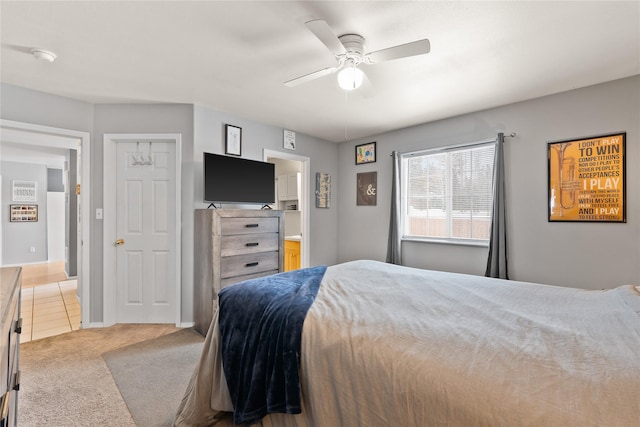 bedroom with light carpet, ceiling fan, and baseboards