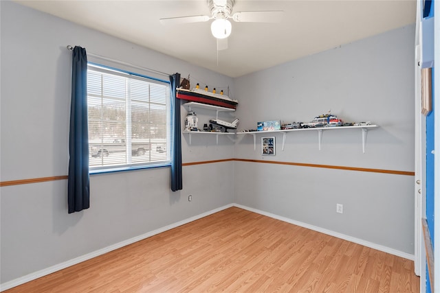 spare room featuring light wood-type flooring, ceiling fan, and baseboards