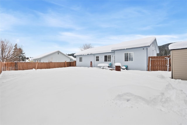 snow covered property with fence