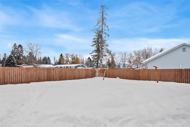 snowy yard featuring fence