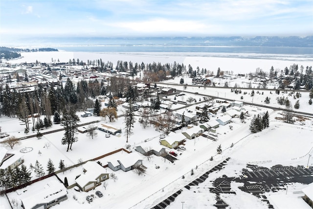 snowy aerial view featuring a water view