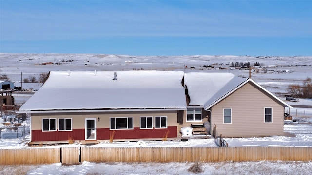 snow covered property featuring fence