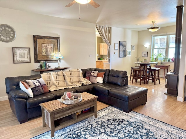 living area with ceiling fan, light wood-style flooring, and baseboards