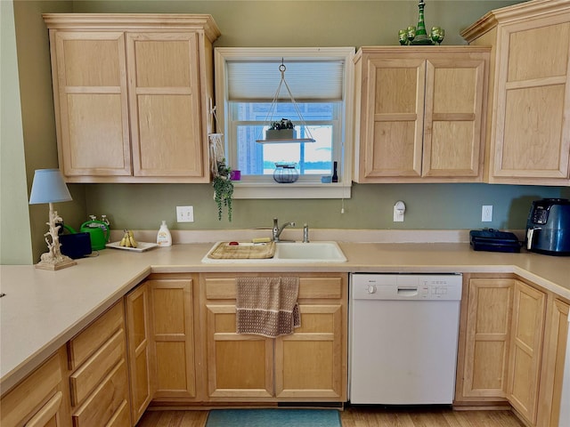 kitchen featuring dishwasher, light countertops, a sink, and light brown cabinets