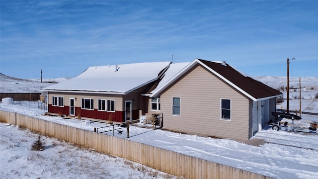 snow covered property with fence