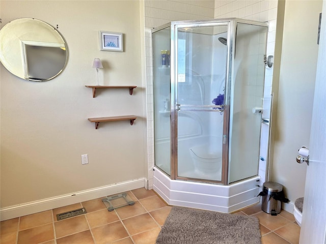 full bath with a stall shower, tile patterned flooring, visible vents, and baseboards