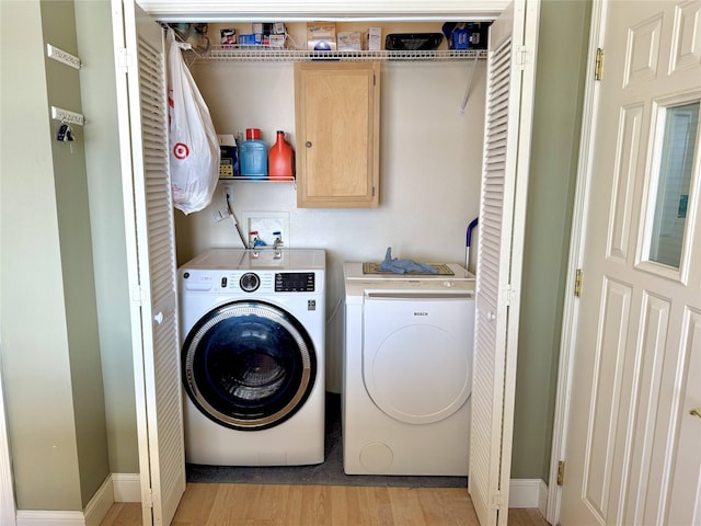 washroom with laundry area, light wood finished floors, and washer and dryer