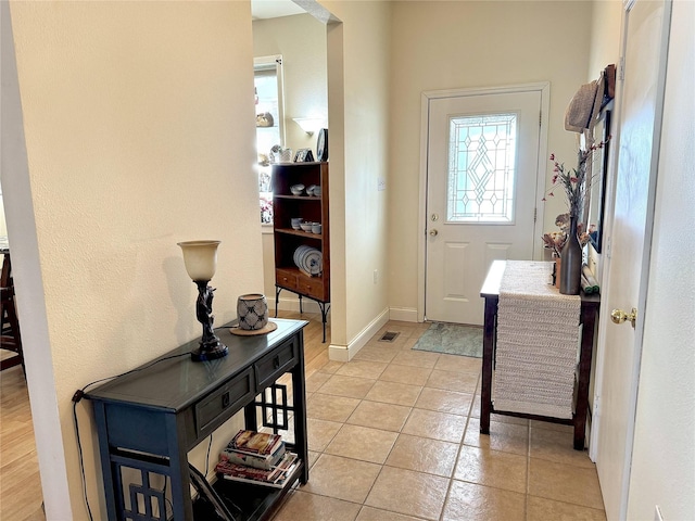 entryway featuring light tile patterned flooring, visible vents, and baseboards