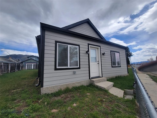 bungalow-style house featuring a front lawn and fence