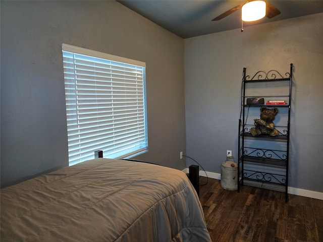 bedroom with dark wood-style flooring, a ceiling fan, and baseboards