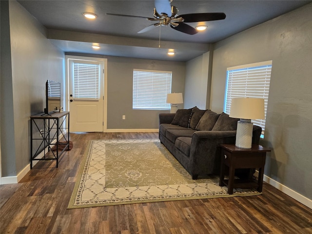 living room featuring ceiling fan, baseboards, and dark wood finished floors