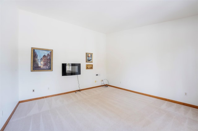 empty room with baseboards and light colored carpet