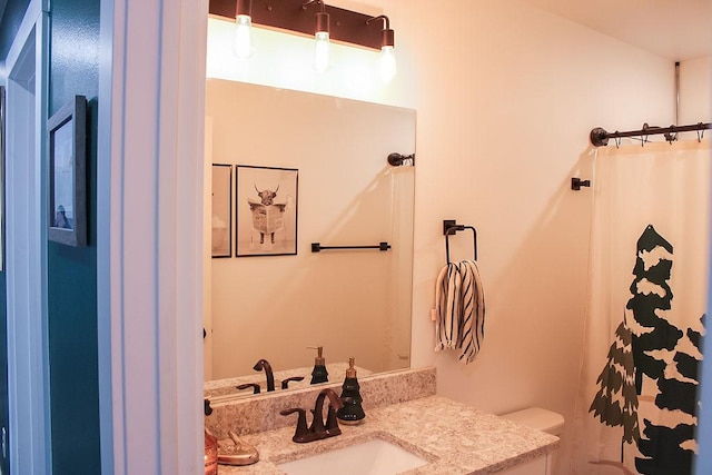 bathroom featuring toilet, a shower with curtain, and vanity