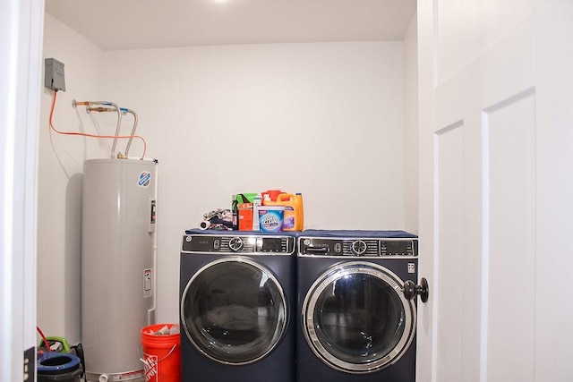 laundry room featuring laundry area, water heater, and washing machine and clothes dryer