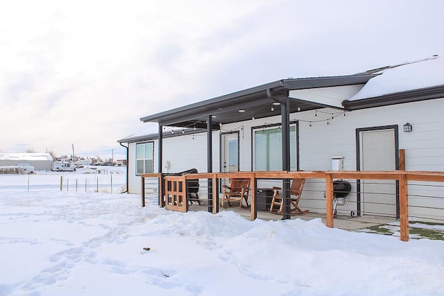 view of snow covered rear of property