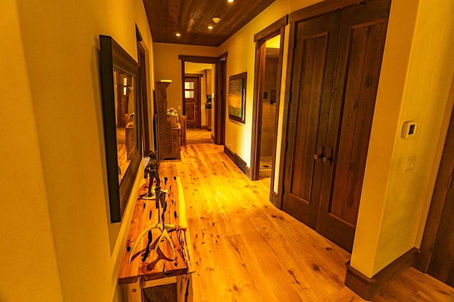 corridor with light wood-style floors, recessed lighting, and baseboards