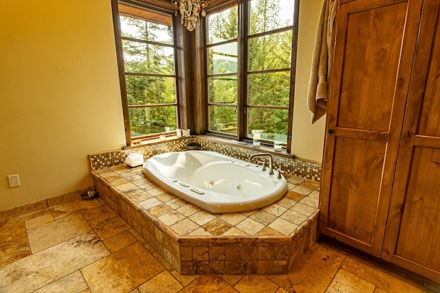 full bathroom with a whirlpool tub and stone tile flooring