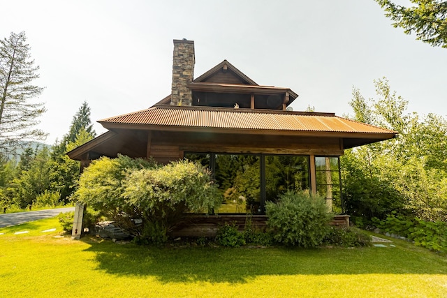 back of property featuring a lawn and a chimney