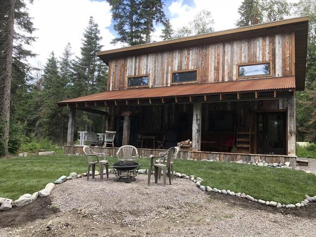 rear view of house featuring a patio area, an outdoor fire pit, and a yard