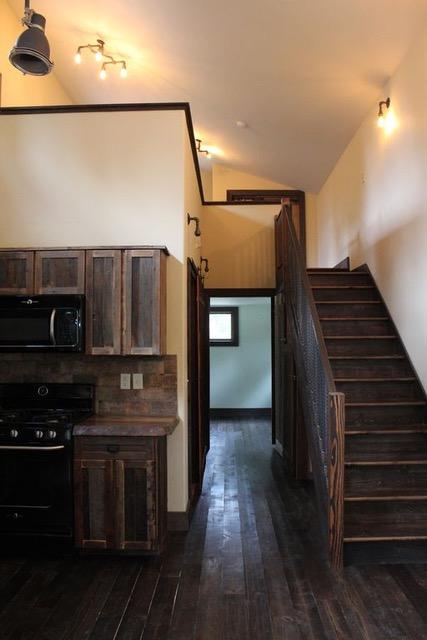 161 Tanglewood Ln, Whitefish, MT 59937 - kitchen featuring black appliances, dark wood finished floors, dark brown cabinets, decorative backsplash, and high vaulted ceiling
