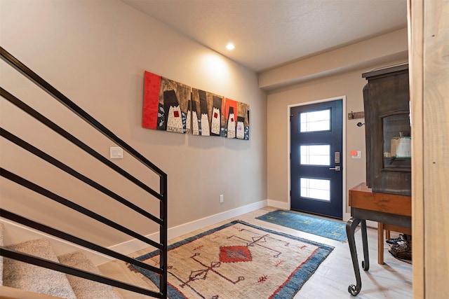 entrance foyer featuring stairs, baseboards, wood finished floors, and a healthy amount of sunlight