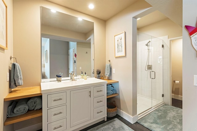 full bath featuring recessed lighting, a shower stall, vanity, and baseboards