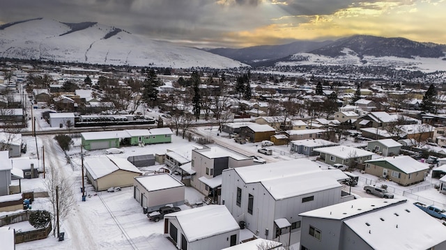 snowy aerial view featuring a residential view and a mountain view