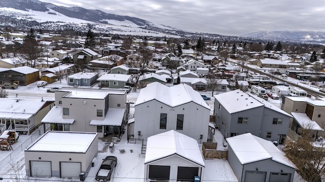 snowy aerial view featuring a residential view and a mountain view